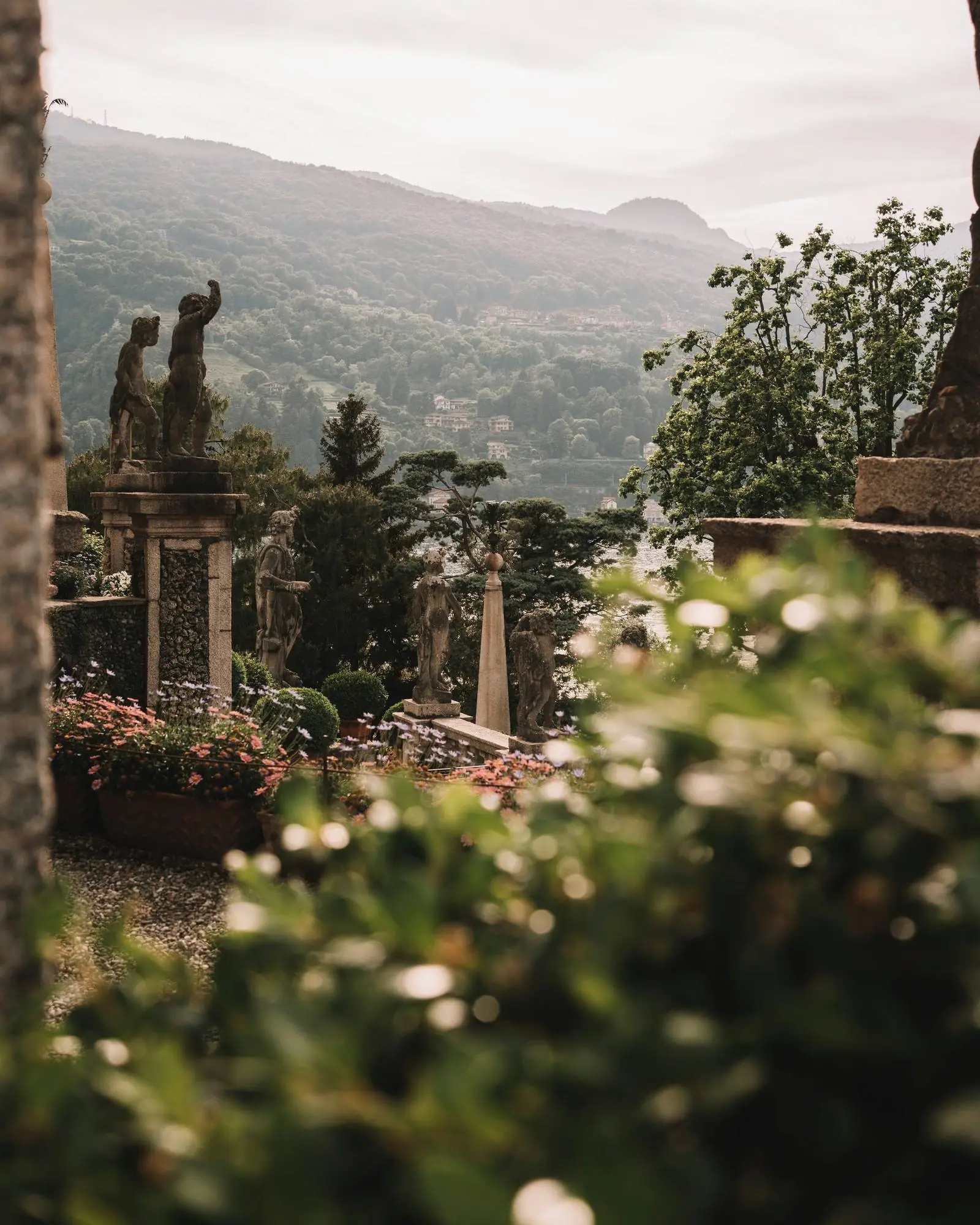 The villa garden with statues and a view across the hills